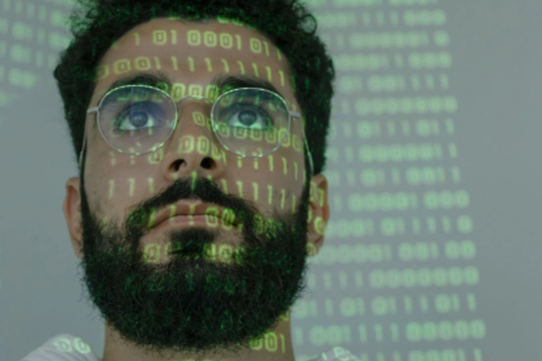 Man with binary code projected on his face, representing digital marketing tech trends and data-driven strategy.