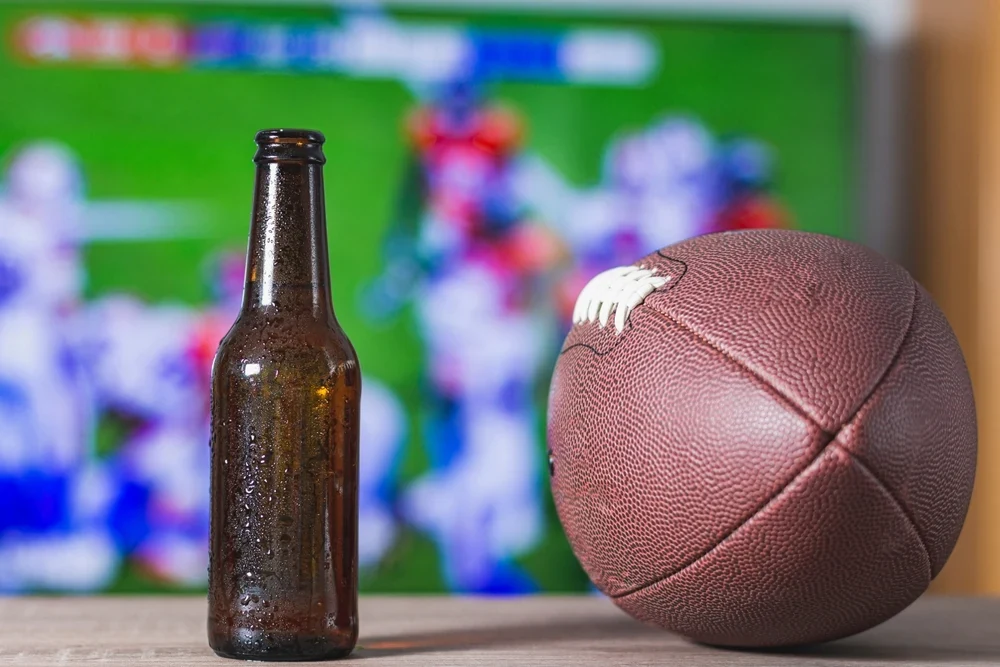 Football, drink bottle, and TV screen representing Super Bowl commercials, CTV advertising, and video marketing.