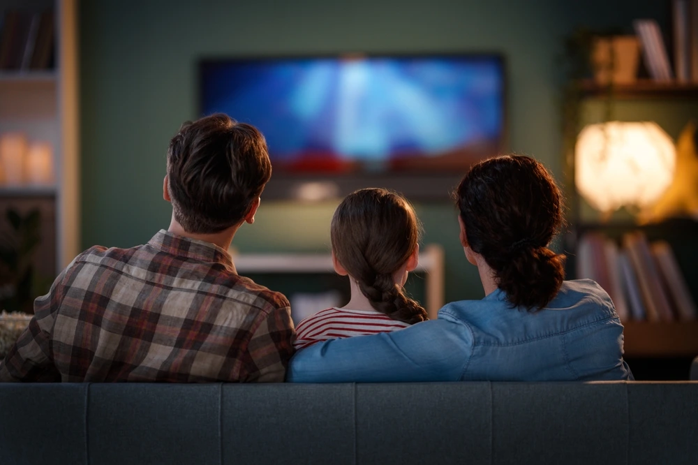 Family watching streaming TV at home, representing CTV advertising and video marketing campaigns for brand awareness.