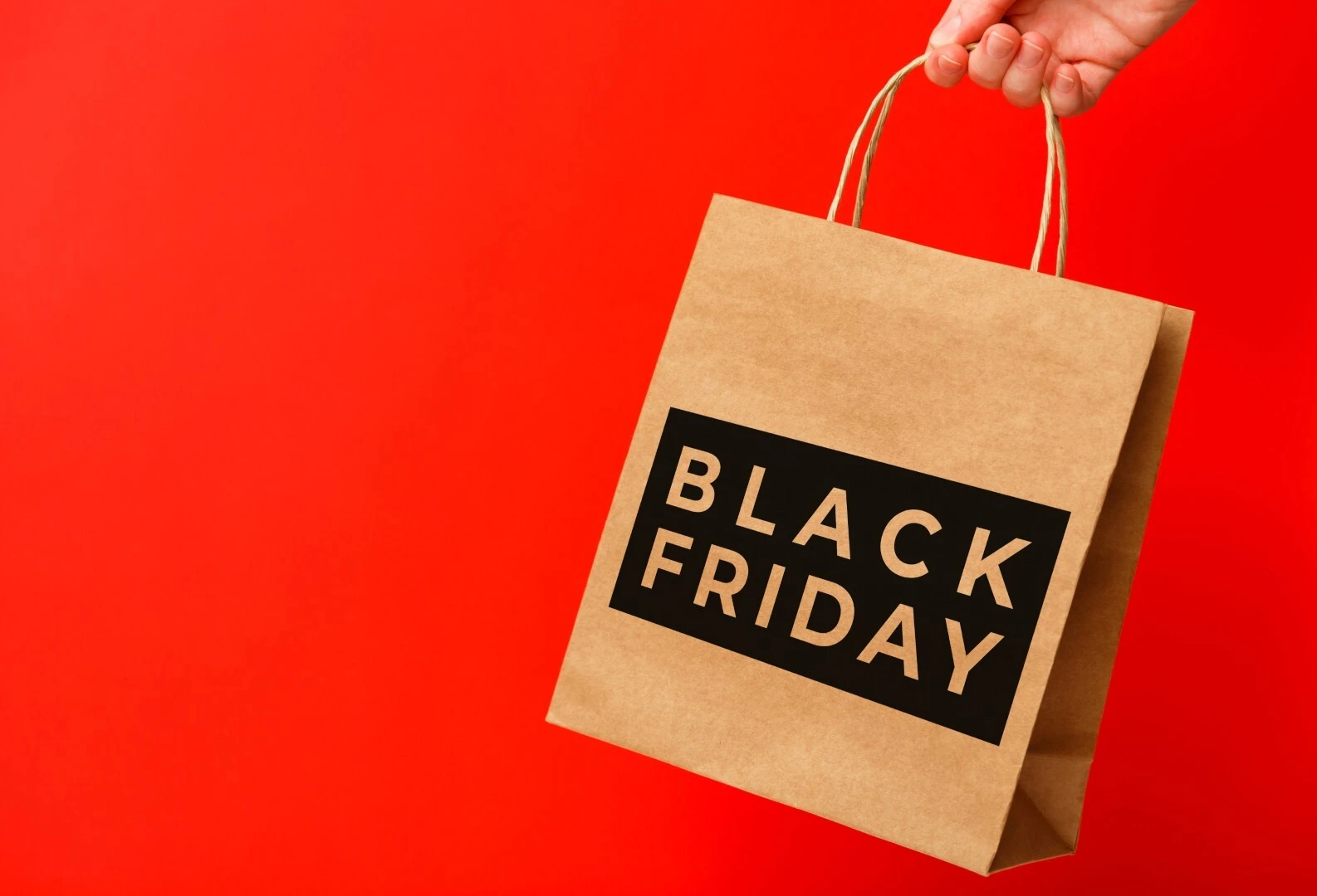 Black Friday shopping bag on red background representing ecommerce promotions, paid ads, and seasonal digital marketing strategy.